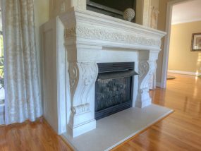 Cast stone fireplace mantel that is traditional and ornate
